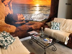uma sala de estar com uma pintura do oceano em L' ALBATROS - 2 chambres - 5 personnes - Proximité de la plage em Bréhal