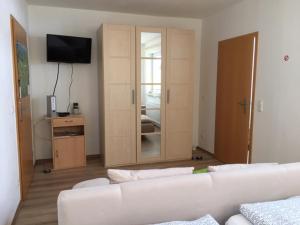 Doppelzimmer Heimatliebe في فالتنهوفن: غرفة معيشة بها أريكة بيضاء وتلفزيون