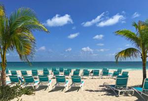 a row of chairs on a beach with the ocean at Catalonia Grand Costa Mujeres All Suites & Spa - All Inclusive in Canc&uacute;n