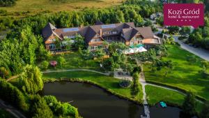 an aerial view of a house with a lake at Hotel Kozi Gród in Pomlewo