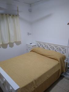 1 dormitorio con 1 cama con manta amarilla en Hospedaje el placer en San Pedro