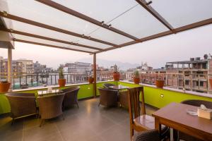 a restaurant with tables and chairs on a balcony at Thamel Boutique Hotel in Kathmandu