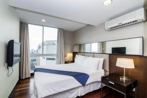 a hotel room with a bed and a television at The Narathiwas Hotel & Residence Sathorn Bangkok in Bangkok
