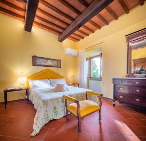 a bedroom with a bed and a chair and a dresser at Portion of Villa with Private pool in Vaglia +16 photos