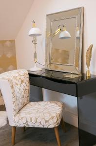 a desk with a chair and a mirror at Sanderson Suites in Harrogate