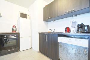 a kitchen with brown cabinets and a white refrigerator at Beautiful Bright Apt With Terrace in Lyon