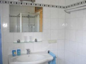a white bathroom with a sink and a mirror at Ferienwohnungen Dippold in Scheßlitz +28 photos