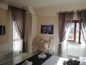 een woonkamer met een tafel en een raam bij OLYMPUS ROOM in Tropea