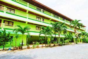 a green building with palm trees in front of it at Rak Samui Residence in Bophut 