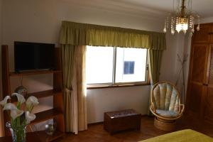 a living room with a window and a chair at Monte da Ria Guest House in Faro