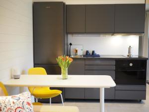 a kitchen with a white table and yellow chairs at Kristina Attefall i Västerhaninge in Västerhaninge