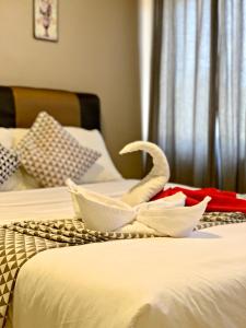ein Hotelzimmer mit 2 Betten und Handtüchern darauf in der Unterkunft Pengkalan Dua in Malakka