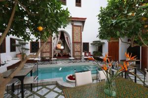 a house with a pool and a table and chairs at Riad Zineb in Marrakesh