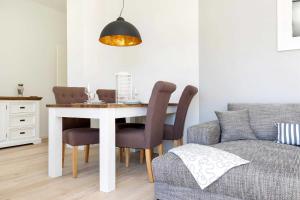 - une table à manger avec des chaises et un canapé dans l'établissement Villa Wiederkehr Heimkehr, à Sellin