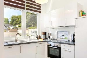 eine weiße Küche mit Spüle und Fenster in der Unterkunft Villa Wiederkehr Heimkehr in Ostseebad Sellin