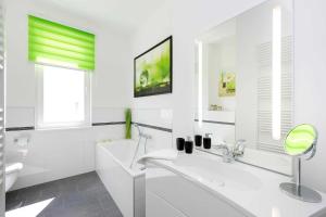 ein weißes Badezimmer mit Badewanne und Waschbecken in der Unterkunft Villa Wiederkehr Heimkehr in Ostseebad Sellin