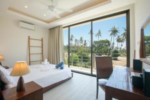 een slaapkamer met een bed, een bureau en een groot raam bij Laem Ka Residence by Tropiclook in Rawai Beach +137 foto's