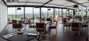 a restaurant with tables and chairs and windows at Domaine De Saint Clair Spa & Golf in Saint-Clair