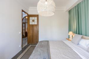 1 dormitorio con cama y lámpara de araña en APG Palau Salieti 3, en Girona