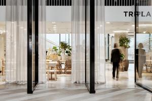 a man is walking through a store window at Original Sokos Hotel Tripla Helsinki in Helsinki