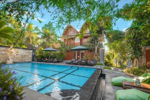 a swimming pool in the backyard of a home with a house at Gunung Merta Bungalows in Ubud