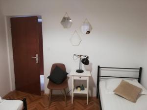 a bedroom with a bed and a chair and a lamp at Guesthouse Radić in Dubrovnik