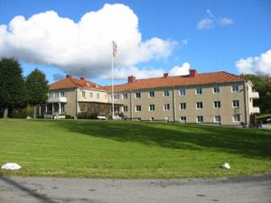 a large building with a grass field in front of it at Partille Vandrarhem in Partille