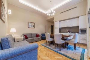 ローマにある900 Apartments Lazio, Emilia & La Corteのリビングルーム(青いソファ、テーブル、椅子付)