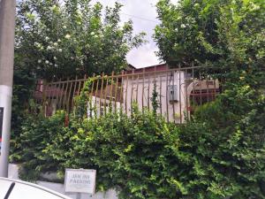 a wooden fence behind some trees and bushes at JSW Inn in Gelugor
