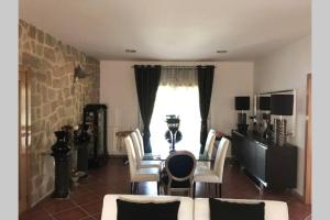RibeiradioにあるHolidays “Villa Familia Silva”のテーブルと椅子と窓のあるリビングルーム