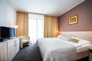 ウヘルスケー・フラジシュチェにあるホテル ムランスカのベッド1台、薄型テレビが備わるホテルルームです。