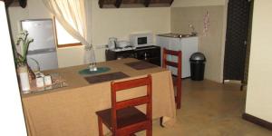 a kitchen with a table and chairs and a refrigerator at Waterberg Accommodation in Modimolle +11 photos