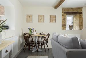 ein Wohnzimmer mit einem Tisch und einem Sofa in der Unterkunft The Bakery in Moreton-in-Marsh