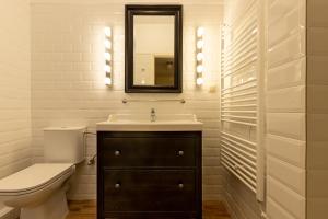 a bathroom with a sink and a toilet and a mirror at Urban Senses Apt #2, a KalamataStay Property in Kalamata
