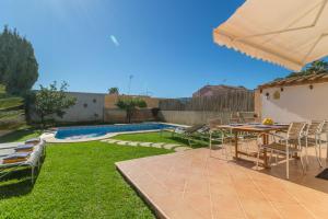 Un patio con mesa y sillas junto a una piscina. en Casa Las Bahias - 3140-16 Mallorca, en Badia Blava