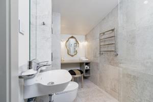 a bathroom with a sink and a toilet and a mirror at Modern Studio Węgierska Cracow by Renters in Krakow