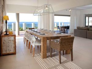 a dining room table and chairs with a view of the ocean at Rockshandy Beachhouse in Southbroom