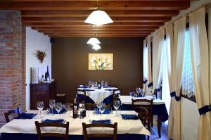 a dining room with two tables and chairs with wine glasses at Agriturismo Ca’ d’Oro in Sarego