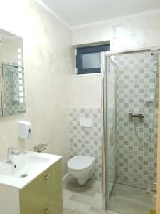 a bathroom with a toilet and a sink and a shower at Villa George in Constanţa
