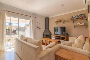 Una sala de estar con un sofá y un televisor. en Casa Las Bahias - 3140-16 Mallorca, en Badia Blava