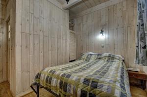 a bedroom with a bed in a wooden wall at Pokoje Gościnne Światłomir in Zakopane
