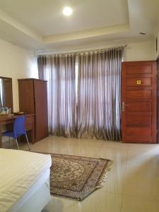 a bedroom with a bed and a desk and a window at Mina Homestay Syariah in Bukittinggi +11 photos