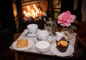 a table with plates of food and a fireplace at Bush Hotel in Carrick on Shannon