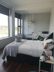 a bedroom with a large white bed and two windows at School house Portaferry in Portaferry