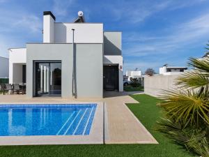 a villa with a swimming pool in front of a house at Luxury villa with private heated pool in Foz do Arelho