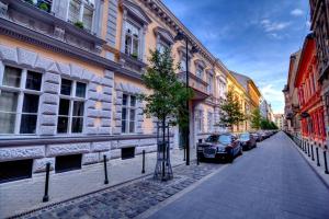 a street with cars parked on the side of a building at Gellerico Rooms at Horánszky Street in Budapest