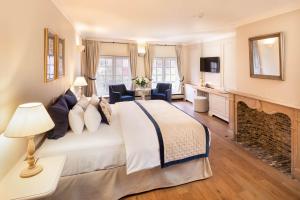 a bedroom with a large bed and a fireplace at De Tuilerieën - Small Luxury Hotels of the World in Bruges