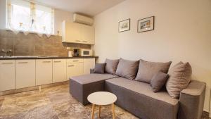 a living room with a couch and a table and a kitchen at Apartment Villa Mare2 with pool, sea view and hydromassage in Banjole