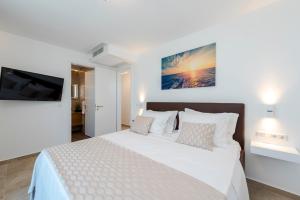 a bedroom with a white bed and a tv at Villa Tadic in Zadar