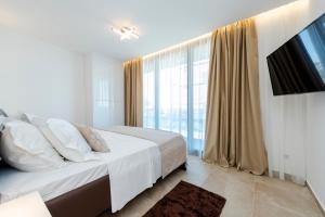 ein Schlafzimmer mit einem Bett und einem großen Fenster in der Unterkunft Villa Tadic in Zadar